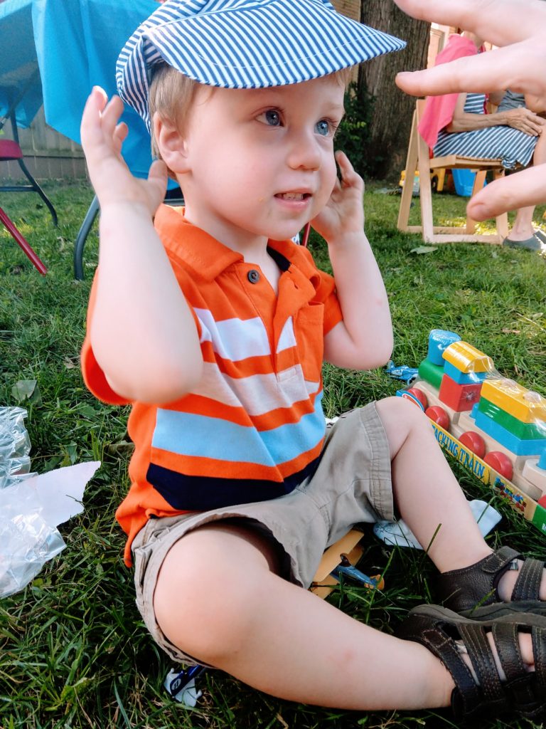 Toddler happy with his new train hat