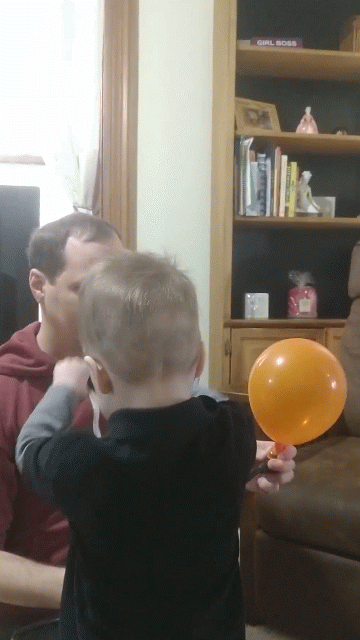 animation of man and toddler blowing up balloons for party