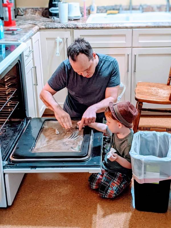 child doing chores in the kitchen with dad