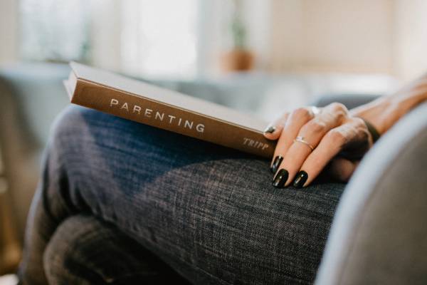 Woman holding parenting book in lap
